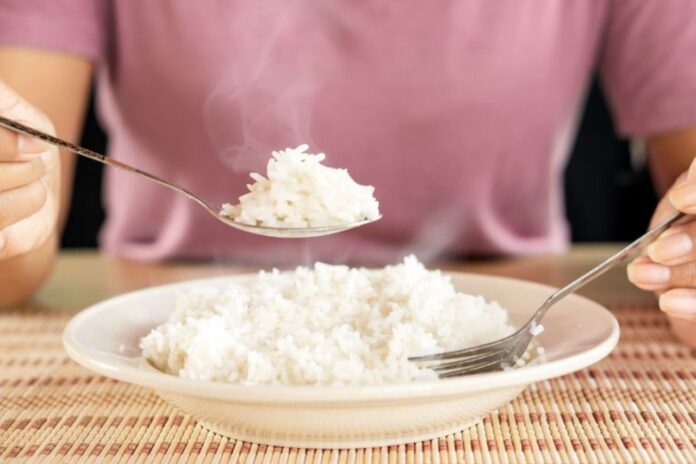 Asian,Woman,Eating,Cooked,Hot,Rice,By,Spoon,In,A